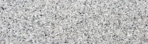 Close-up texture of Bianco Sardo Granite. A uniform light grey Italian granite with granular quartz and feldspar structure. Ideal for commercial flooring.